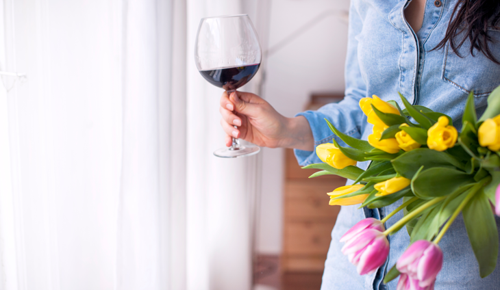 Woman holding wine and flowers