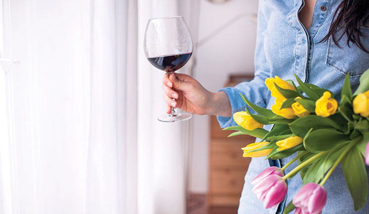 Woman holding tulips and a glass of wine