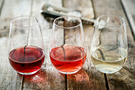 Red, white and rosé wine in wine glasses.